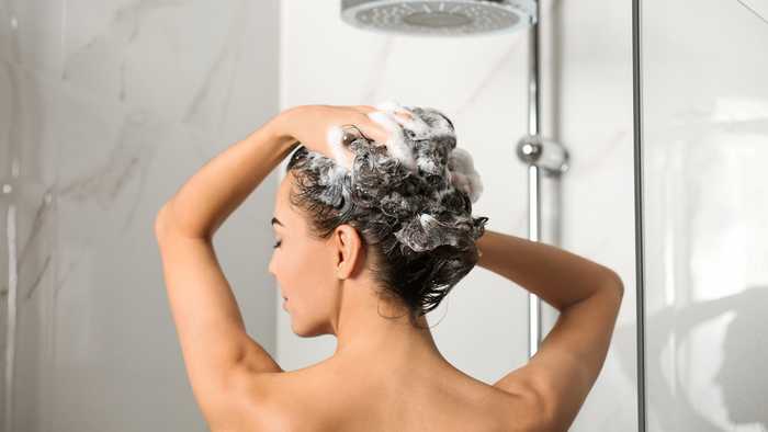 Lady washing her curly hair in the shower Lady washing her curly hair in the shower