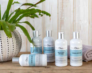 Vegan shower gels, shampoos and conditioners laid on a bathroom floor