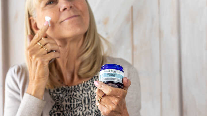 lady applying moisturiser to her face with a combination skin type