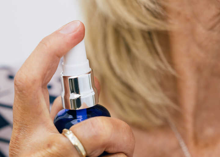 Woman spraying Oleo Bodycare Eau de Toilette on her neck